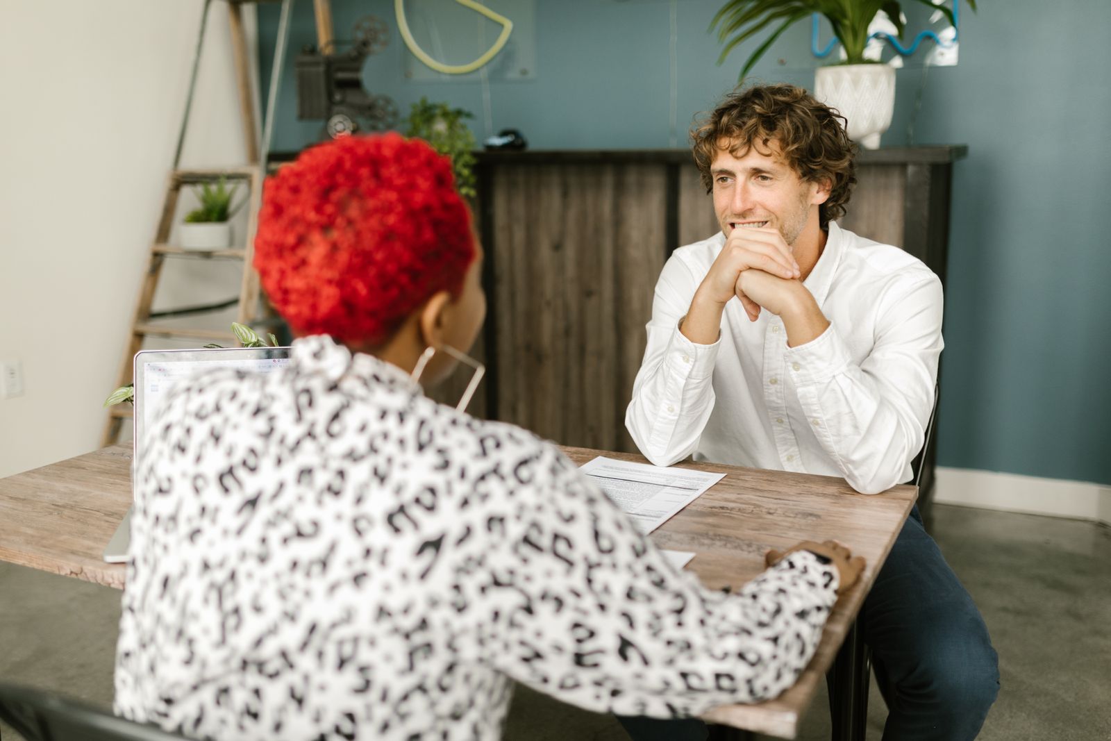 Un recruteur écoute une candidate pendant un entretien, de part et d’autre d’une table